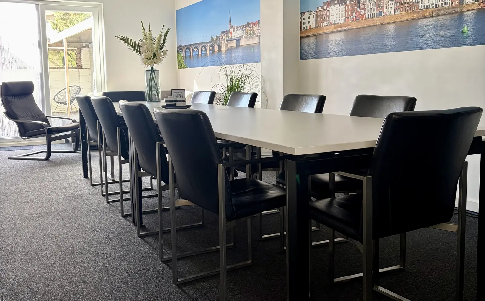 Lange vergadertafel voor 12 personen met schuifpui naar de tuin in Vergaderruimte Maastricht