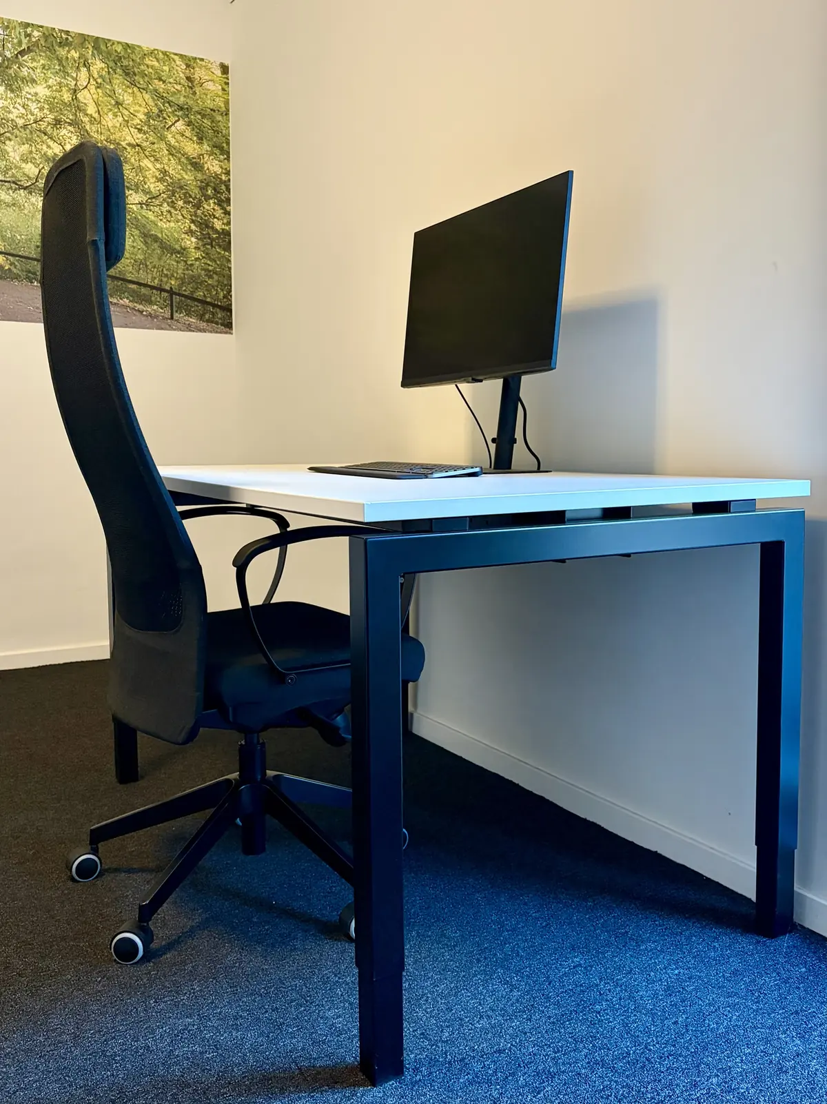 Werkplek huren in Maastricht: bureau met monitor, toetsenbord en ergonomische bureaustoel